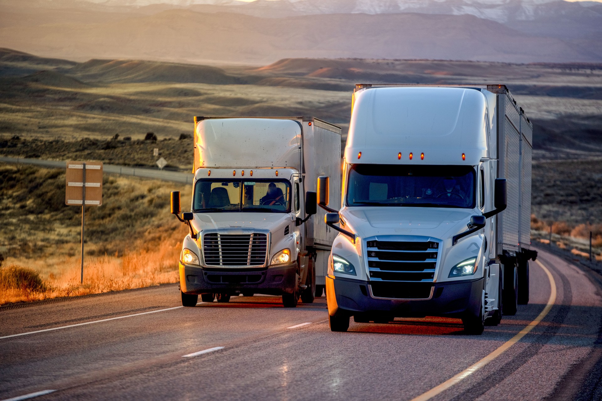 Long Haul Semi-Truck Rolling Down a Four-Lane Highway at Dusk